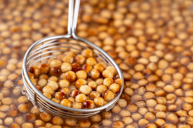 Cocinar, hervir bolas de perlas de tapioca con sabor a azúcar morena, ingrediente de té de burbujas, preparar comida y bebida, primer plano, concepto de diseño de pasos de libro de cocina de recetas.