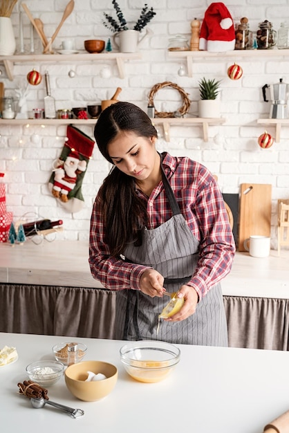 Cocinar y hornear joven mujer latina vertiendo la miel a la masa cocinando en la cocina