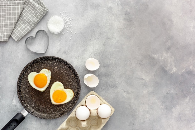 Cocinar huevos fritos en forma de corazón en una sartén