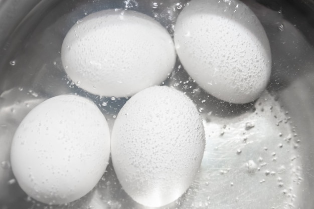 Cocinar huevos de gallina blanca en una cacerola.