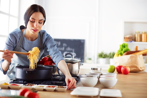 Cocinar a la mujer en la cocina con cuchara de madera