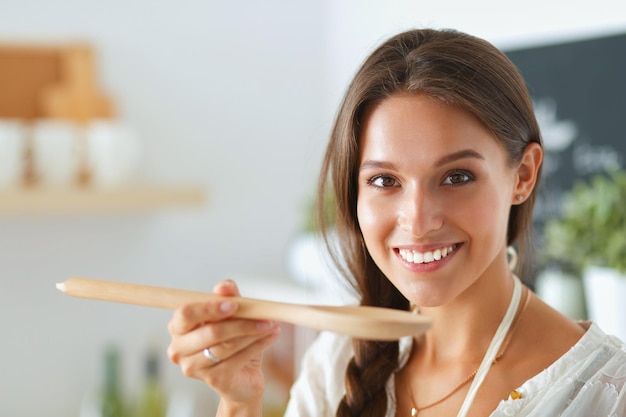 Cocinar a la mujer en la cocina con cuchara de madera