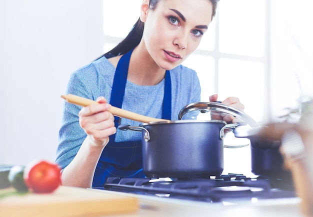 Cocinar a la mujer en la cocina con cuchara de madera