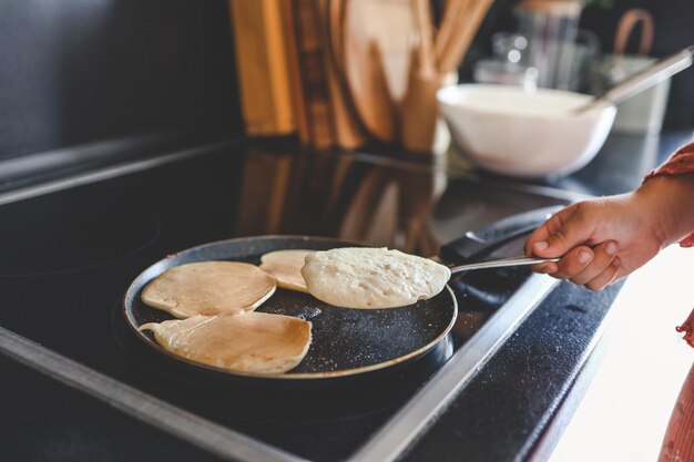 Cocinar panqueques para el desayuno en una sartén