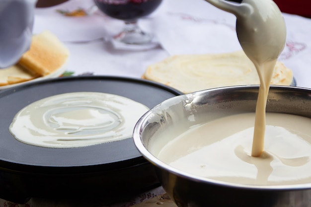 Cocinar panqueques. Vierta la masa para panqueques en una sartén.