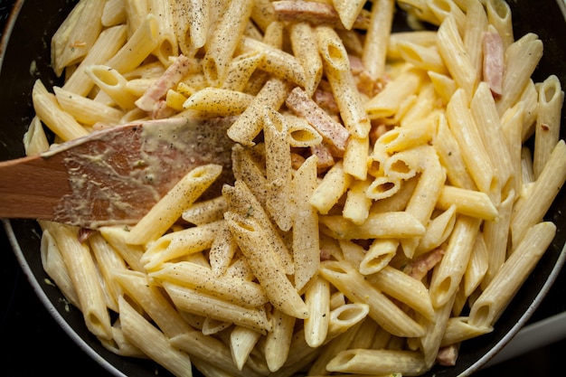 Cocinar pasta carbonara con jamón Jamón frito especias y hierbas en salsa