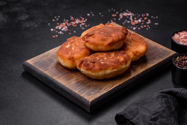 Cocinar pasteles con patata en una tabla de cortar de madera