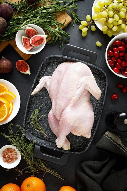 Cocinar pavo de Navidad con ingredientes para cocinar en la vista superior de fondo negro Todo crudo