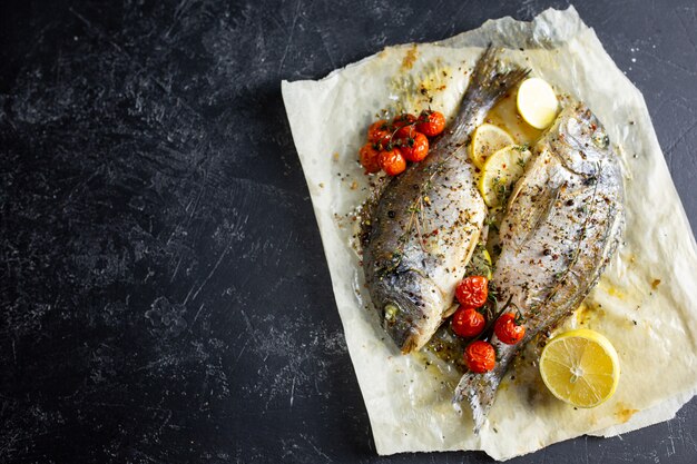 Cocinar pescado en el horno. Cocinar dorado con tomates cherry y hierbas en pergamino en el horno.