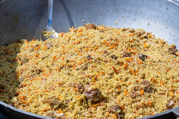 Cocinar pilaf tradicional en caldero grande en el mercado de comida de la calle en Ucrania, cerrar