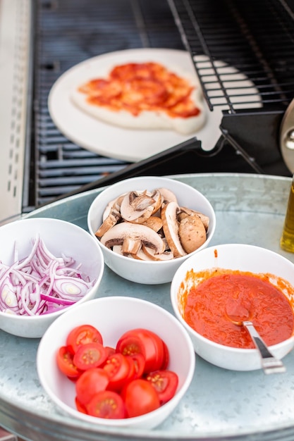 Cocinar pizza en parrilla de gas al aire libre.