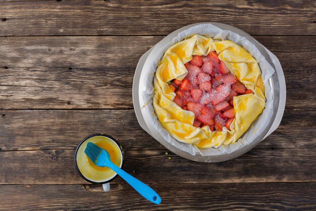 Cocinar tarta de fresa sobre un fondo de madera. Cocina casera