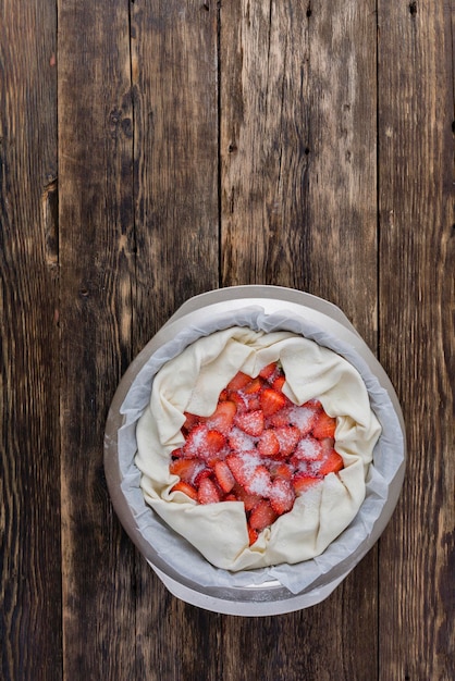 Cocinar tarta de fresa sobre un fondo de madera. Cocina casera