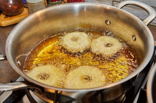 Cocinar tortitas de manzana Rosquilla de manzana en aceite hirviendo