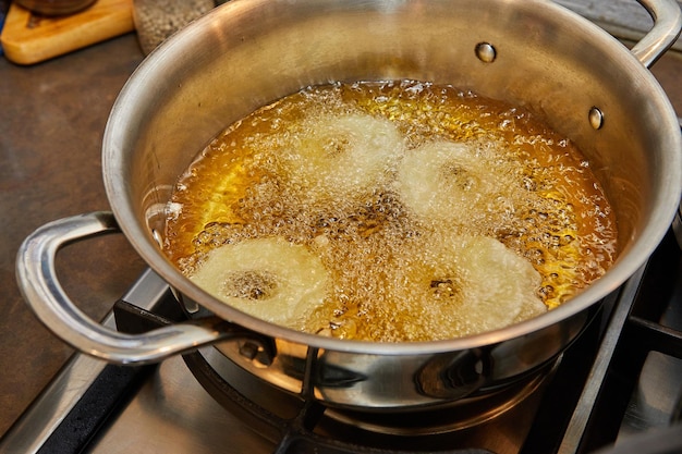 Cocinar tortitas de manzana Rosquilla de manzana en aceite hirviendo