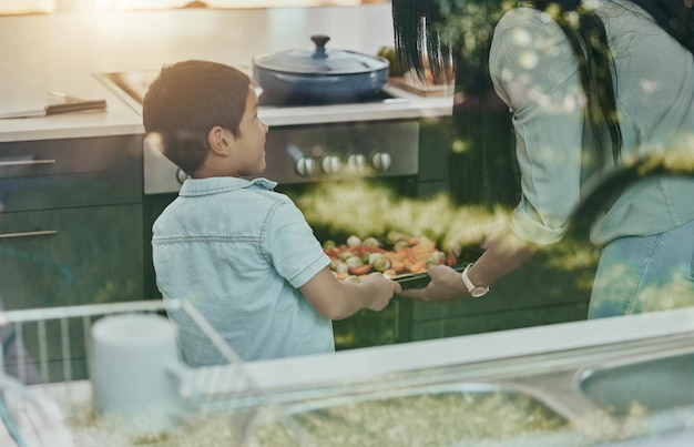 Foto cocinar verduras y niños ayudando a la madre con la preparación de alimentos y aprendiendo en el horno en la cocina desayuno feliz y mamá y niño preparando el almuerzo, la cena o un refrigerio juntos en su casa familiar