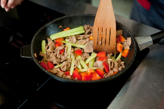 Cocine la carne de papas fritas en una sartén con verduras