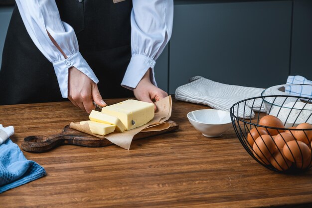 Foto cocine los cortes de mantequilla sobre la mesa con los ingredientes.