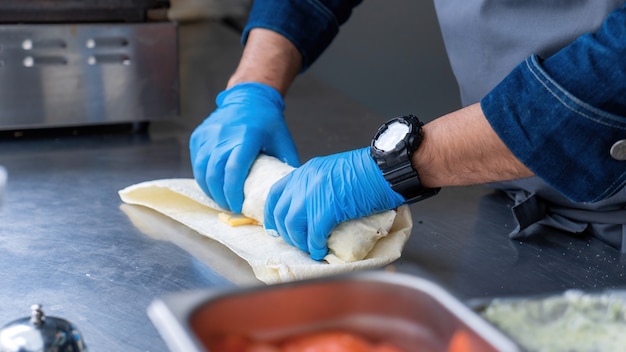 Cocine enrollando una envoltura en un camión de comida