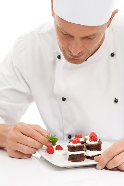 Foto cocine el postre y la menta en chocolate dulce o bayas en la comida del chef culinario con receta en un plato con fondo de estudio blanco presentación de cocina y hombre o persona haciendo mini pasteles como cocina