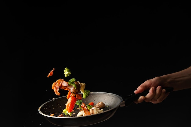 Foto cocine preparando rebanadas de tocino con ajo y pimiento picante y brócoli en una sartén