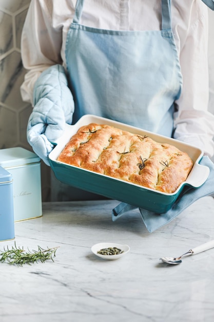 Foto cocine sosteniendo un pastel en un recipiente con las dos manos