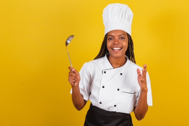 Cocinera afro brasileña joven sosteniendo un cucharón de cocina accesorio de cocina