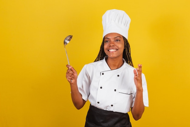 Cocinera afro brasileña joven sosteniendo un cucharón de cocina accesorio de cocina