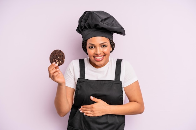 Cocinera afro negra con trenzas y haciendo una galleta