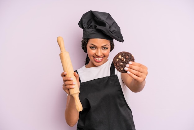 Foto cocinera afro negra con trenzas y haciendo una galleta