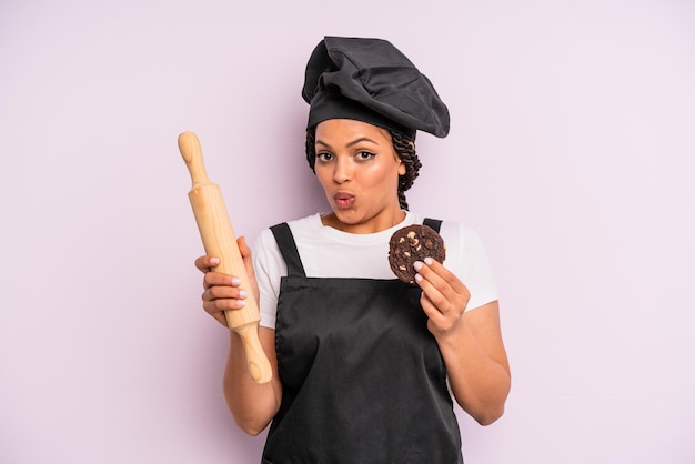 Cocinera afro negra con trenzas y haciendo una galleta