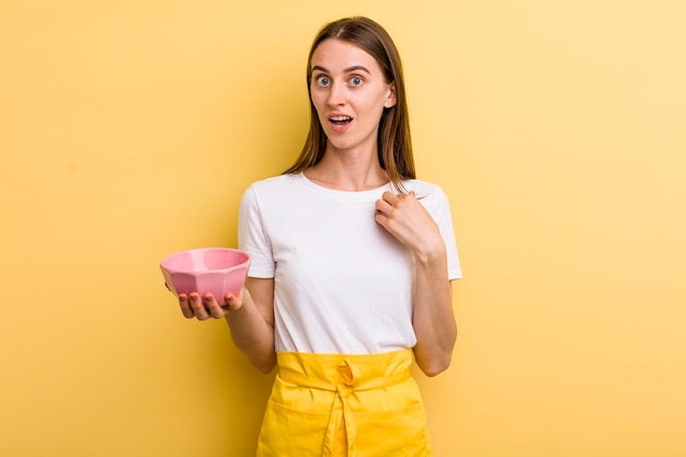 Cocinera bonita adulta joven con un cuenco vacío