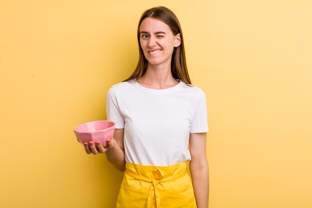 Cocinera bonita adulta joven con un cuenco vacío