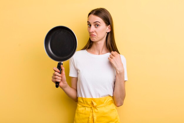 Foto cocinera bonita adulta joven con una sartén