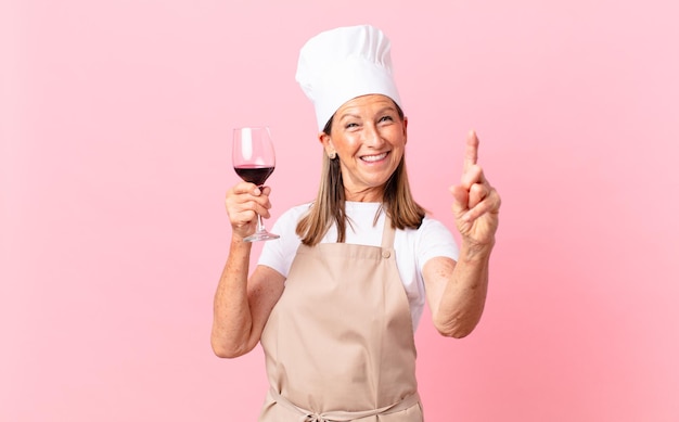 Cocinera bonita de mediana edad con una copa de vino