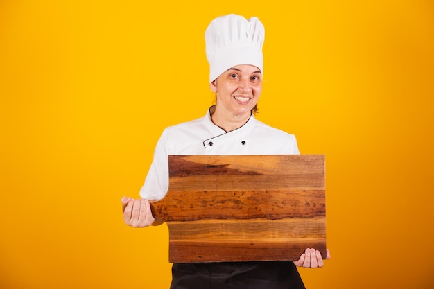 Cocinera brasileña adulta maestra en gastronomía con tablero de madera