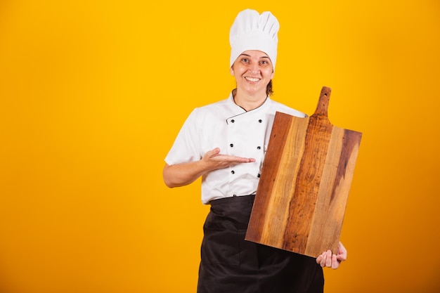 Cocinera brasileña adulta maestra en gastronomía con tablero de madera