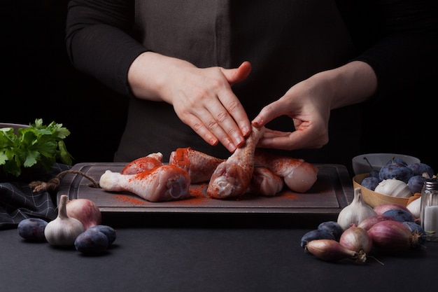 Una cocinera prepara un pollo.