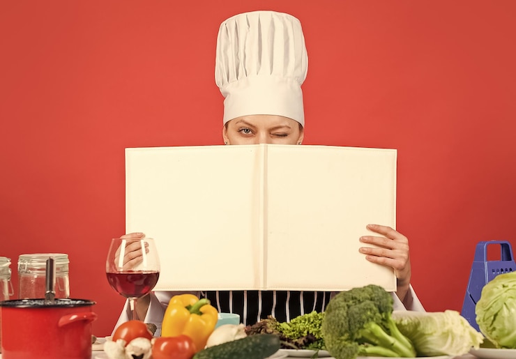Foto cocinera preparando platos en su cocina el libro de recetas abierto para una cocina saludable guarda un secreto sobre los ingredientes que usa la mujer el chef profesional del libro de cocina lee la receta para cocinar espacio de copia