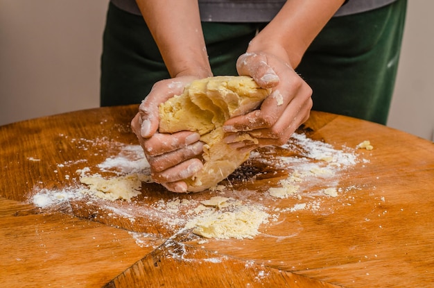 El cocinero amasa la masa de galletas con las manos.