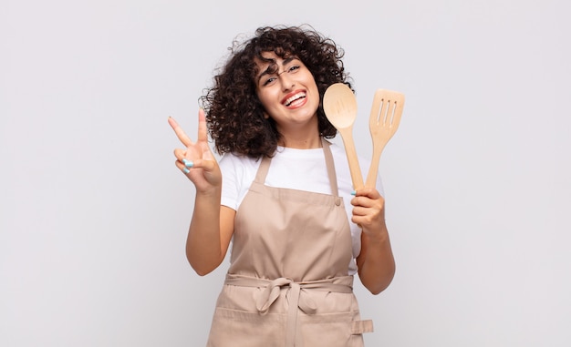 Cocinero árabe de la mujer bonita que lleva un delantal.