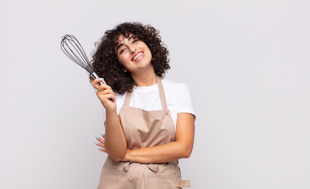 Cocinero árabe de la mujer bonita que lleva un delantal.