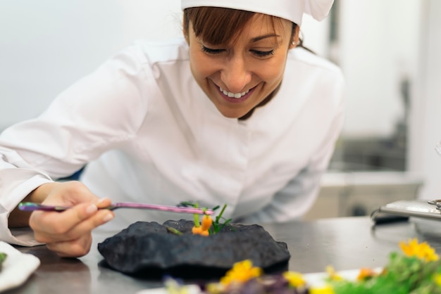 Foto cocinero bastante profesional que cocina en una cocina.