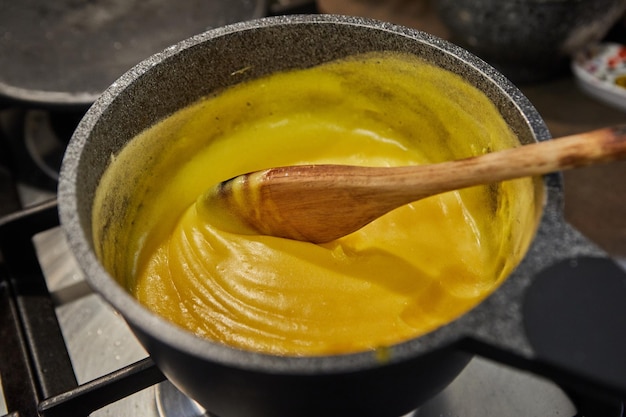 El cocinero cocina crema de pasiflora para hacer pastel.