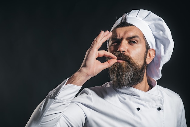 Cocinero cocinero barbudo serio o panadero gesticulando excelente chef masculino en uniforme blanco con signo perfecto