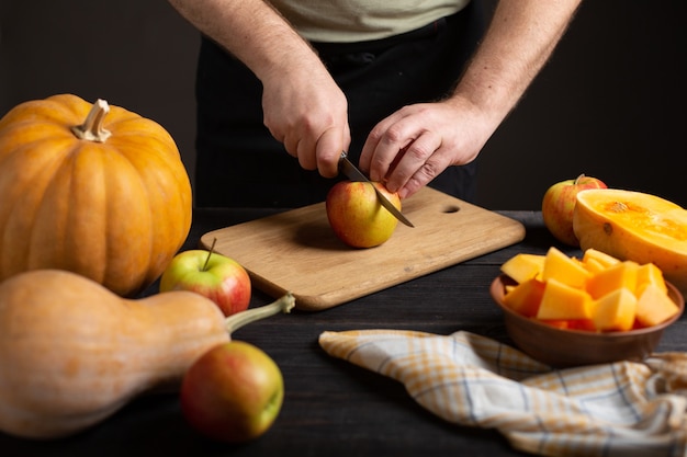 El cocinero corta la manzana en trozos para hornear.