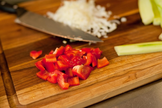 Foto el cocinero corta las verduras con un cuchillo para preparar el plato cortando verduras