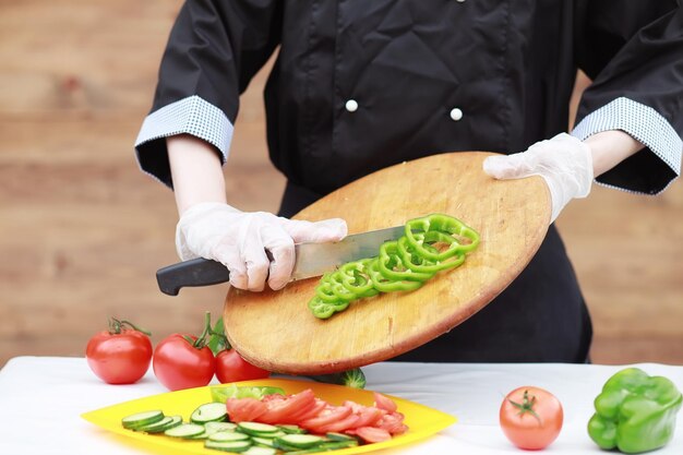 El cocinero corta verduras frescas de granja.