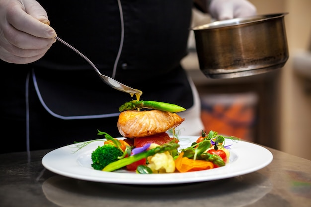 Foto el cocinero decora el plato.