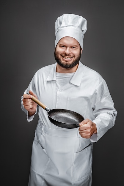 Cocinero emocionado mostrando sartén vacía